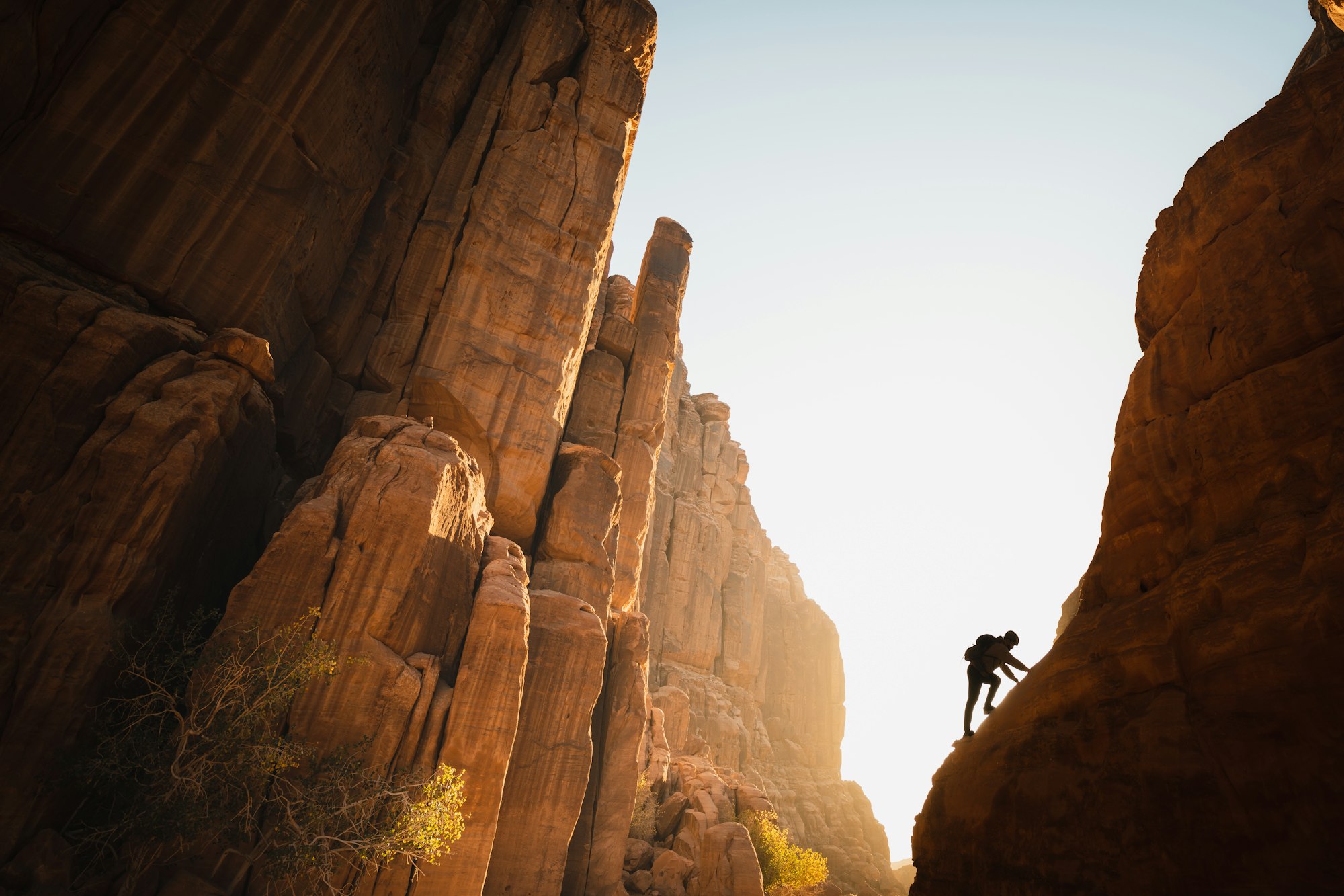 un hombre subiendo la ladera de una montaña