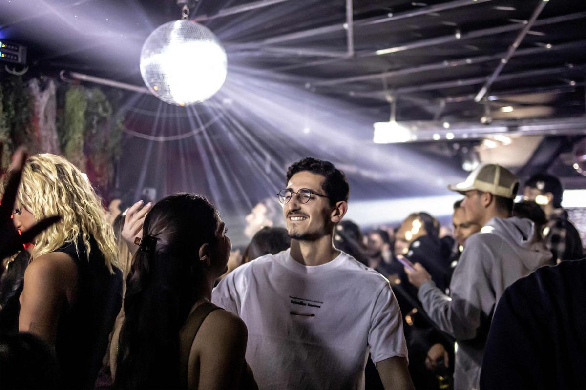 TOPSHOT - Los clientes bailan en un club clandestino utilizado como refugio antiaéreo en Tel Aviv el 9 de marzo de 2026. Una semana después del inicio de la ofensiva israelí-estadounidense contra Irán, los días y las noches de millones de israelíes se ven interrumpidos por repetidas sirenas que les advierten que se dirijan a refugios contra los misiles iraníes entrantes. Israel también ha desarrollado un sofisticado sistema de alerta que advierte a los residentes a través de sus teléfonos móviles cuando se detectan misiles entrantes. (Foto de OLYMPIA DE MAISMONT / AFP) / Atención editores: La AFP cubre la guerra en Medio Oriente a través de su extensa red regional, que incluye oficinas en Teherán, Jerusalén y varios países vecinos. Desde el inicio del conflicto, los periodistas han estado trabajando en condiciones cada vez más restrictivas. Las autoridades de varios países han limitado los movimientos de los periodistas y la cobertura fotográfica y de vídeo en directo desde lugares sensibles. Algunos gobiernos y grupos armados han prohibido imágenes de ataques con misiles o drones y otros sitios relacionados con la seguridad. /. VER TÍTULO PARA MÁS INFORMACIÓN / Atención editores: AFP cubre la guerra en Medio Oriente a través de su extensa red regional, incluidas oficinas en Teherán, Jerusalén y varios países vecinos. Desde el inicio del conflicto, los periodistas han