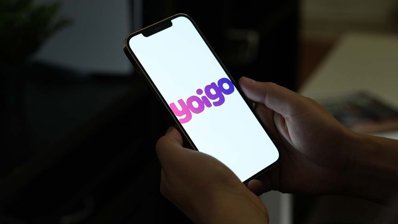 Teléfono móvil con logo de Yoigo y fondo blanco.