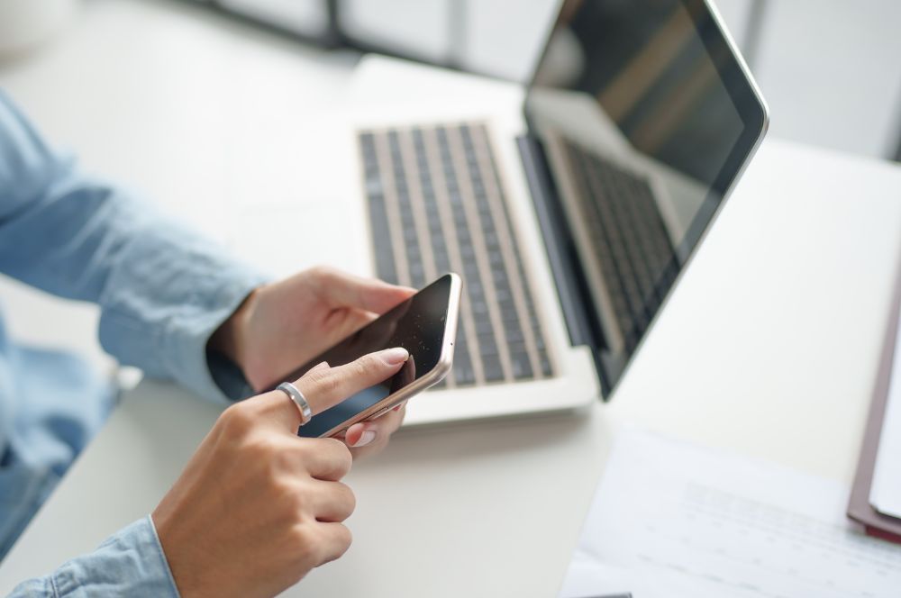 Personas con teléfonos móviles y portátiles.