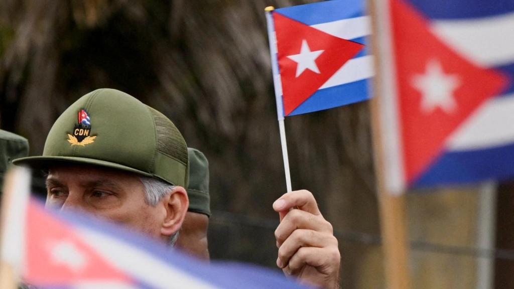 El presidente de Cuba, Miguel Díaz-Canel, ondea una bandera cubana durante una marcha frente a la Embajada de Estados Unidos para protestar contra lo que denuncian como una agresión estadounidense en la región, en La Habana, Cuba, el 16 de enero de 2026.