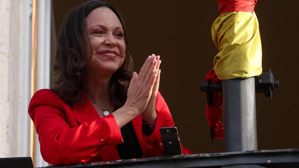 La líder de la oposición venezolana, María Corina Machado, gesticula desde un balcón tras recibir la Medalla de Oro de la Comunidad de Madrid de manos de la presidenta regional Isabel Díaz Ayuso, durante su visita a España.