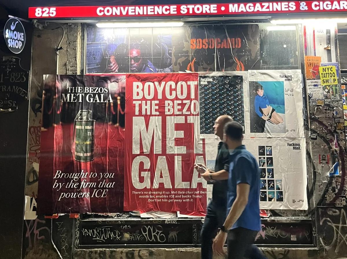 Varias personas caminan delante de un cartel que pide boicotear la Met Gala en Nueva York, el 16 de abril.