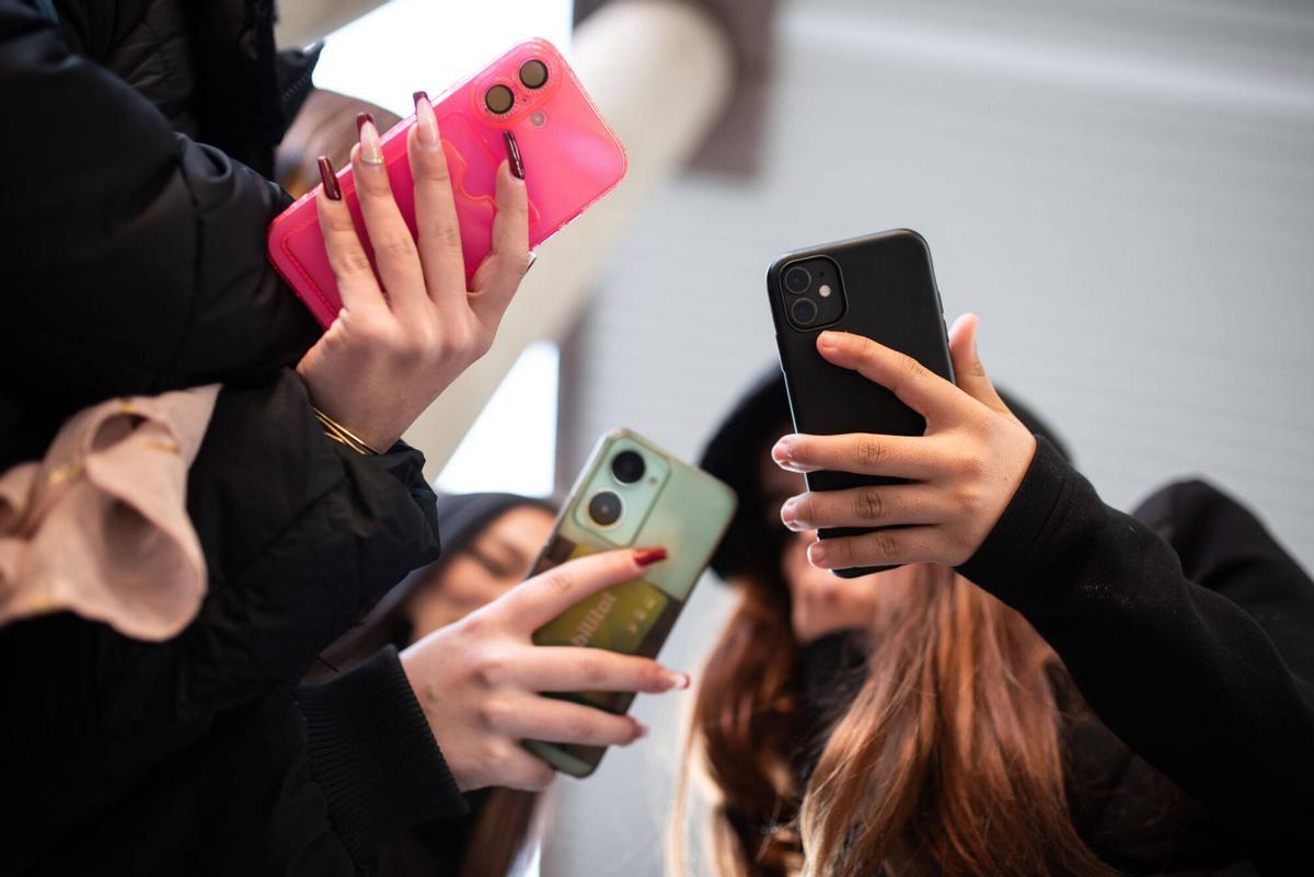 Algunos jóvenes utilizan teléfonos móviles con funda, en una imagen de archivo.