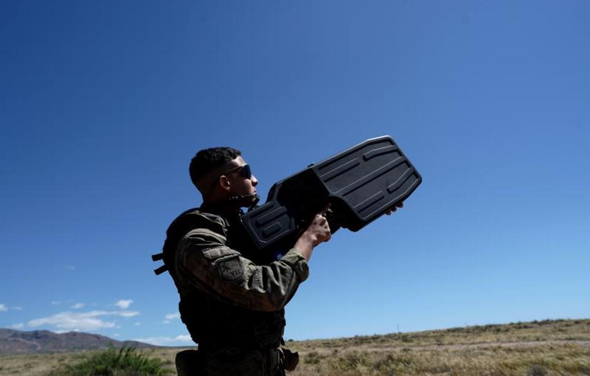 Un legionario apunta al cielo con una escopeta electrónica anti-drones.