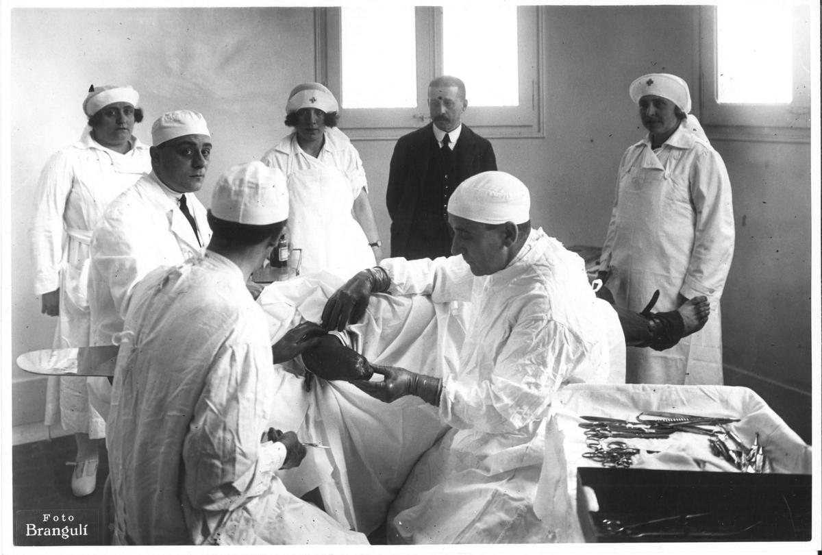 Francesc Moragas (director general de la Caja de Ahorro y Pensiones para la Vejez), observando una intervención quirúrgica para adaptar una prótesis (1922). Instituto para la rehabilitación física de mutilados.