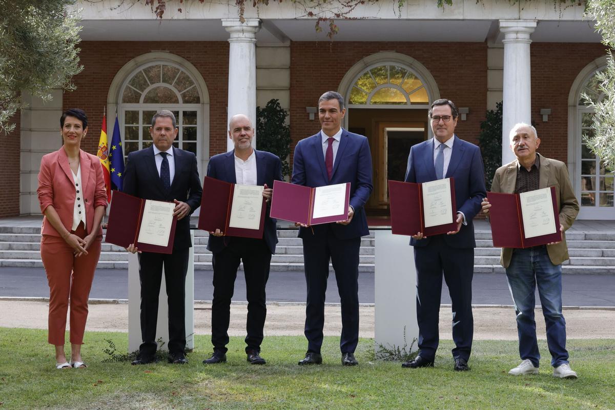 El presidente del Gobierno, Pedro Sánchez (c), posa con los representantes de la patronal y de los sindicatos durante la firma del nuevo acuerdo en materia de pensiones.
