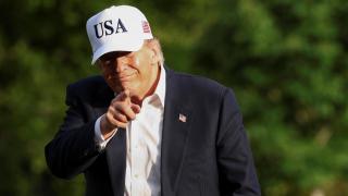 Donald Trump hace un gesto al regresar a la Casa Blanca tras su viaje a China.