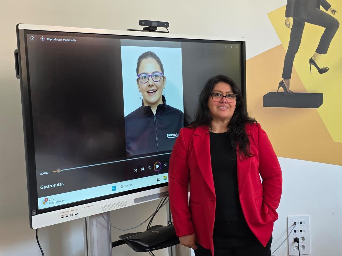 Selia Rojas, ganadora del concurso, posando junto al vídeo de presentación de su proyecto Gastrorutas.