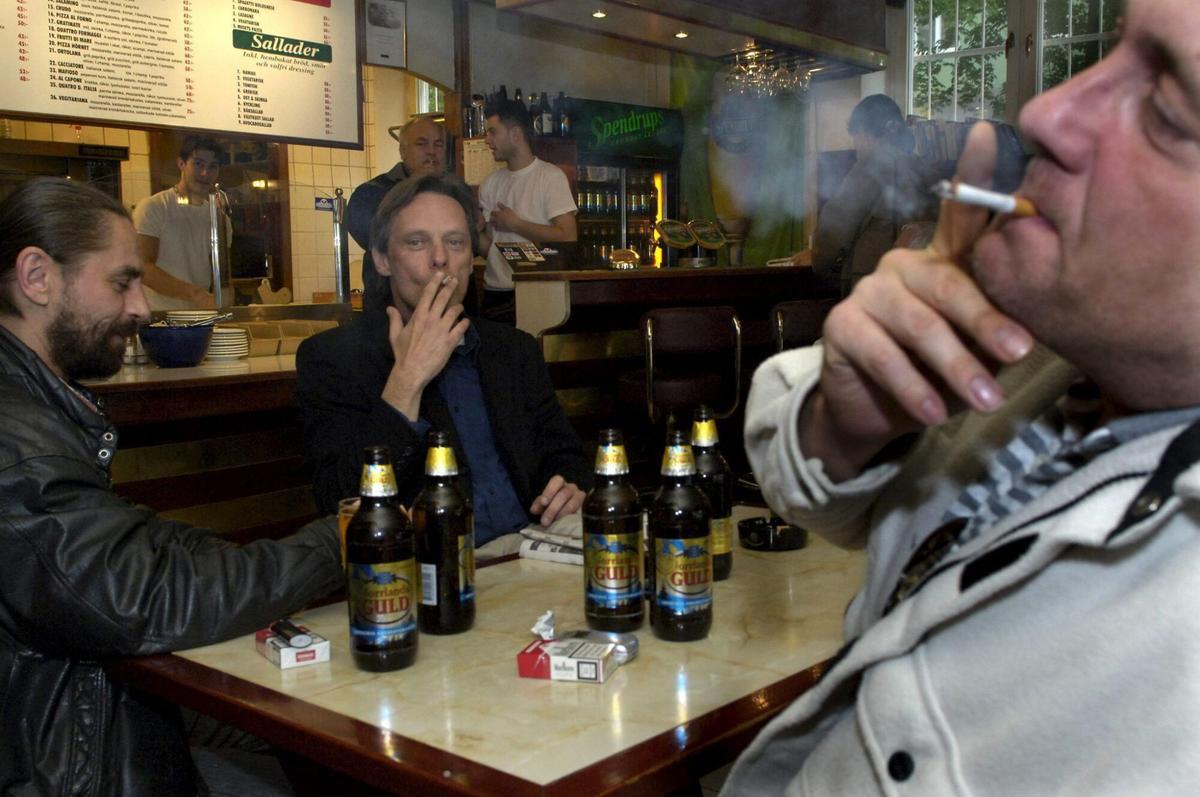 STO01.ESTOCOLMO.(SUECIA).31/5/2005.-Tres hombres disfrutan de un cigarrillo con su cerveza en una pizzería en Estocolmo hoy, 31 de mayo de 2005. La nueva ley que prohíbe fumar en restaurantes, bares y cafeterías en Suecia entra en vigor en las primeras horas del martes. EFE/LEIF R JANSSON. TABACO. CIGARRILLOS. FUMADORES.