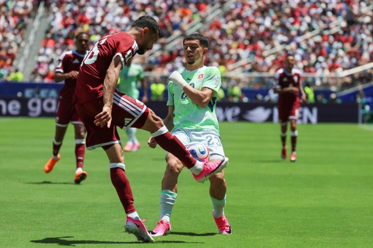 Boualem Khoukhi, de Qatar, disputa el balón con Zeki Amdouni, de Suiza, en partido del Grupo B del Mundial 2026