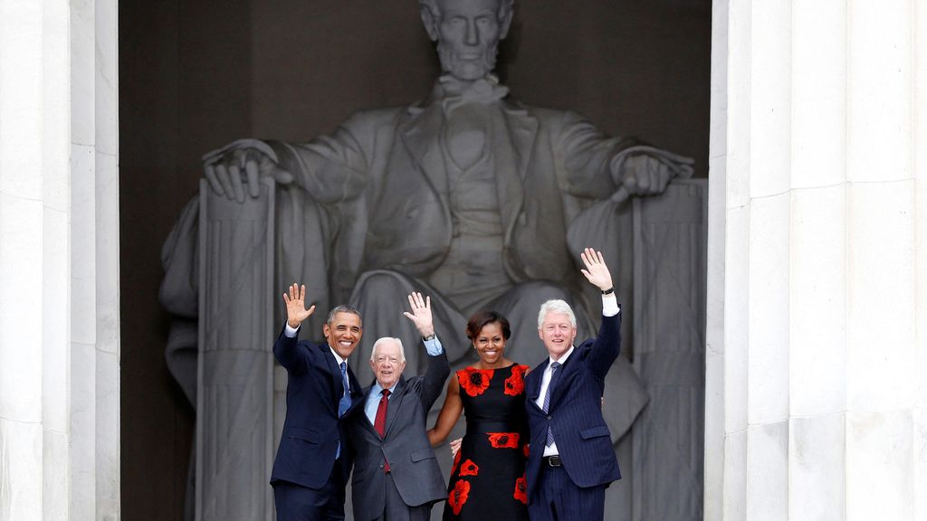 Barack Obama, Jimmy Carter, Michelle Obama y Bill Clinton saludan desde las escaleras del Monumento a Lincoln.