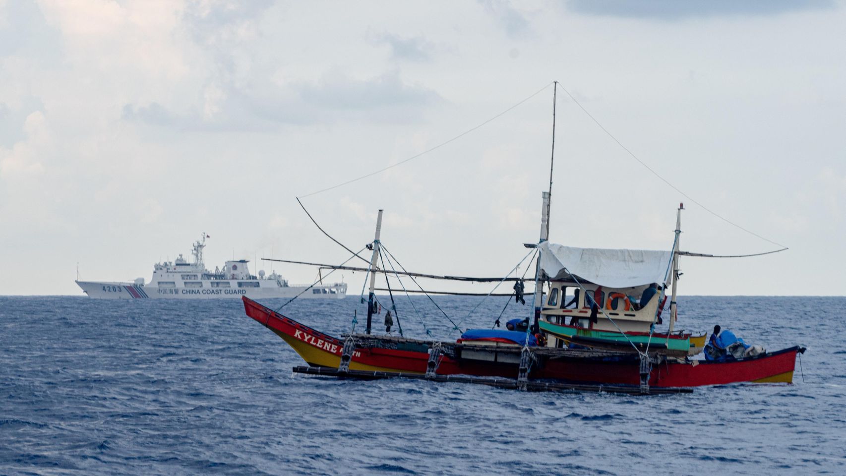 El barco pesquero filipino Kylene y el guardacostas chino 4203 navegan por las aguas en disputa de Masinloc Shoals.