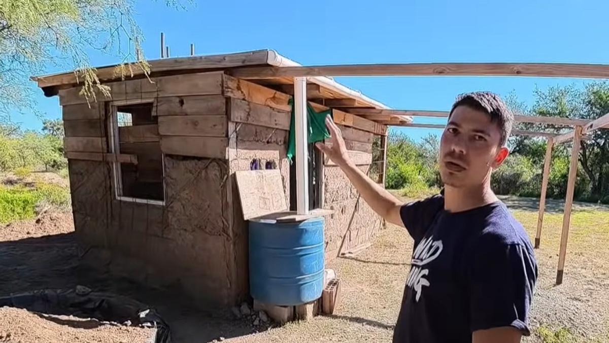 Mauricio construye una casa de madera, paja y barro en la montaña.