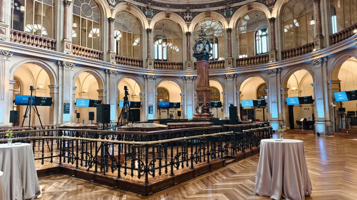 El interior del Palazzo della Bolsa de Madrid, con su singular estructura circular, ventanas de arco de medio punto y un gran reloj central sobre un pedestal.
