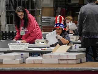 Trabajadores del Registro Electoral procesan votos por correo en EE.UU. para las elecciones de 2024.