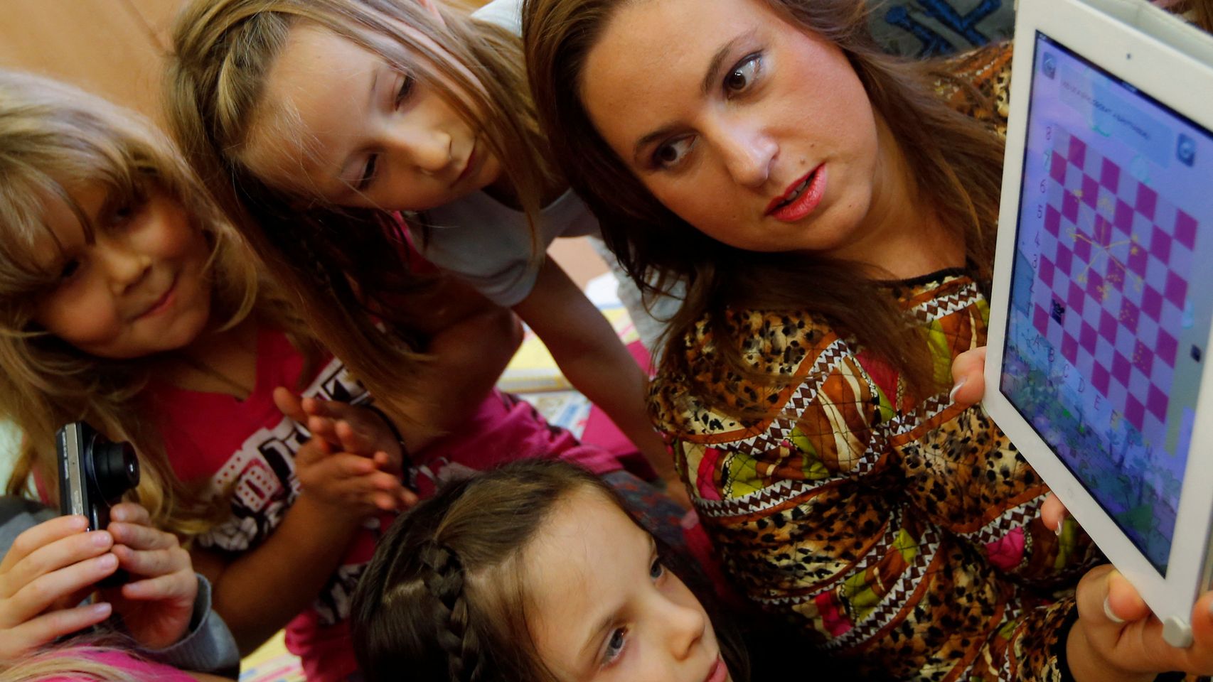 Judit Polgár muestra su iPad para jugar al ajedrez a varios niños en Budapest en 2013