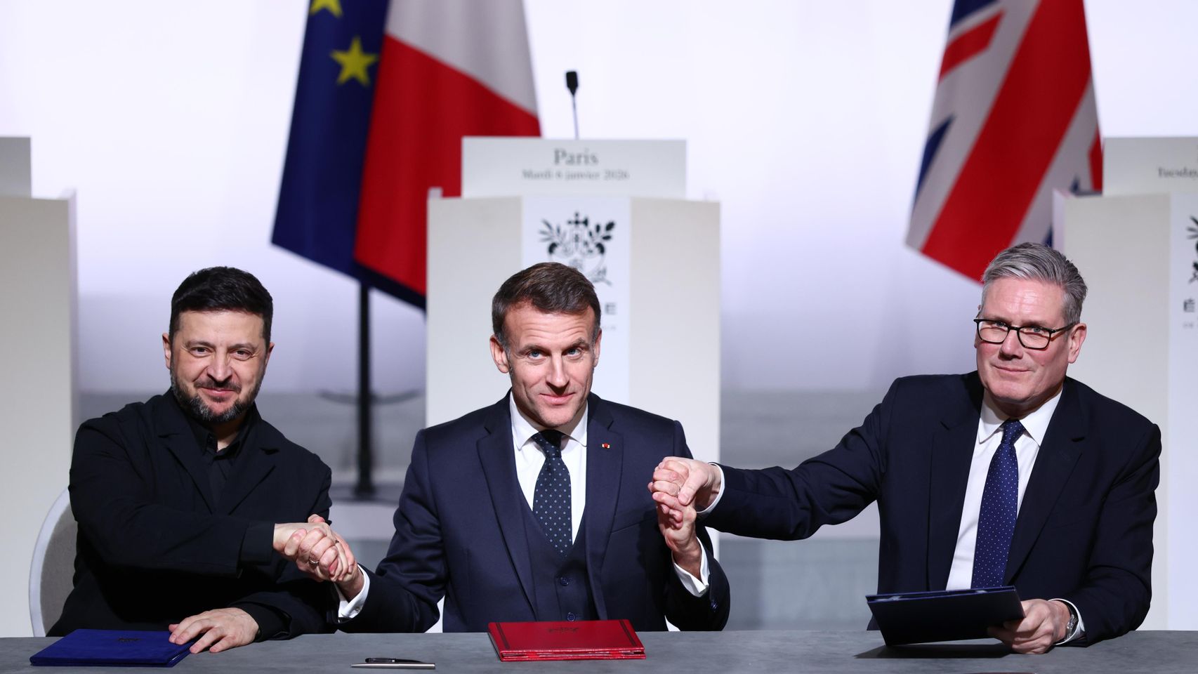 El presidente Voldymyr Zelensky, el presidente Emmnauel Macron y el primer ministro Keir Starmer se dan la mano en la última cumbre de la Coalición de Voluntarios.
