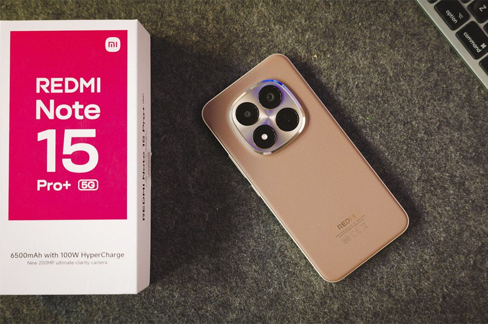 El teléfono dorado Xiaomi Redmi Note 15 Pro+ 5G se encuentra junto a la caja oficial con un acabado gris.