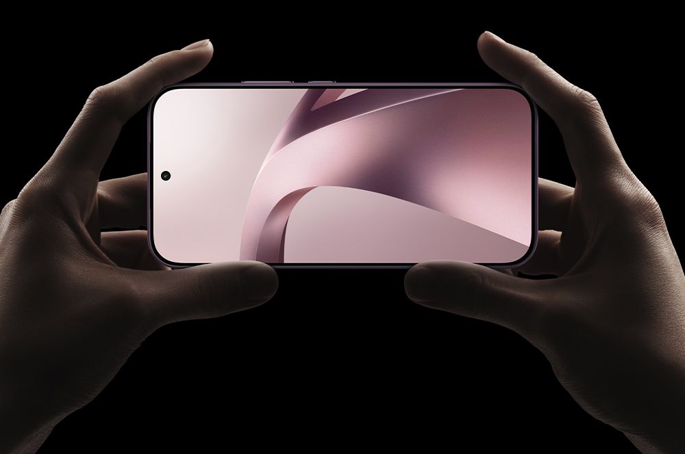 El teléfono inteligente Xiaomi se sostiene horizontalmente con ambas manos, mostrando biseles de pantalla reducidos y una cámara frontal perforada sobre un fondo oscuro.